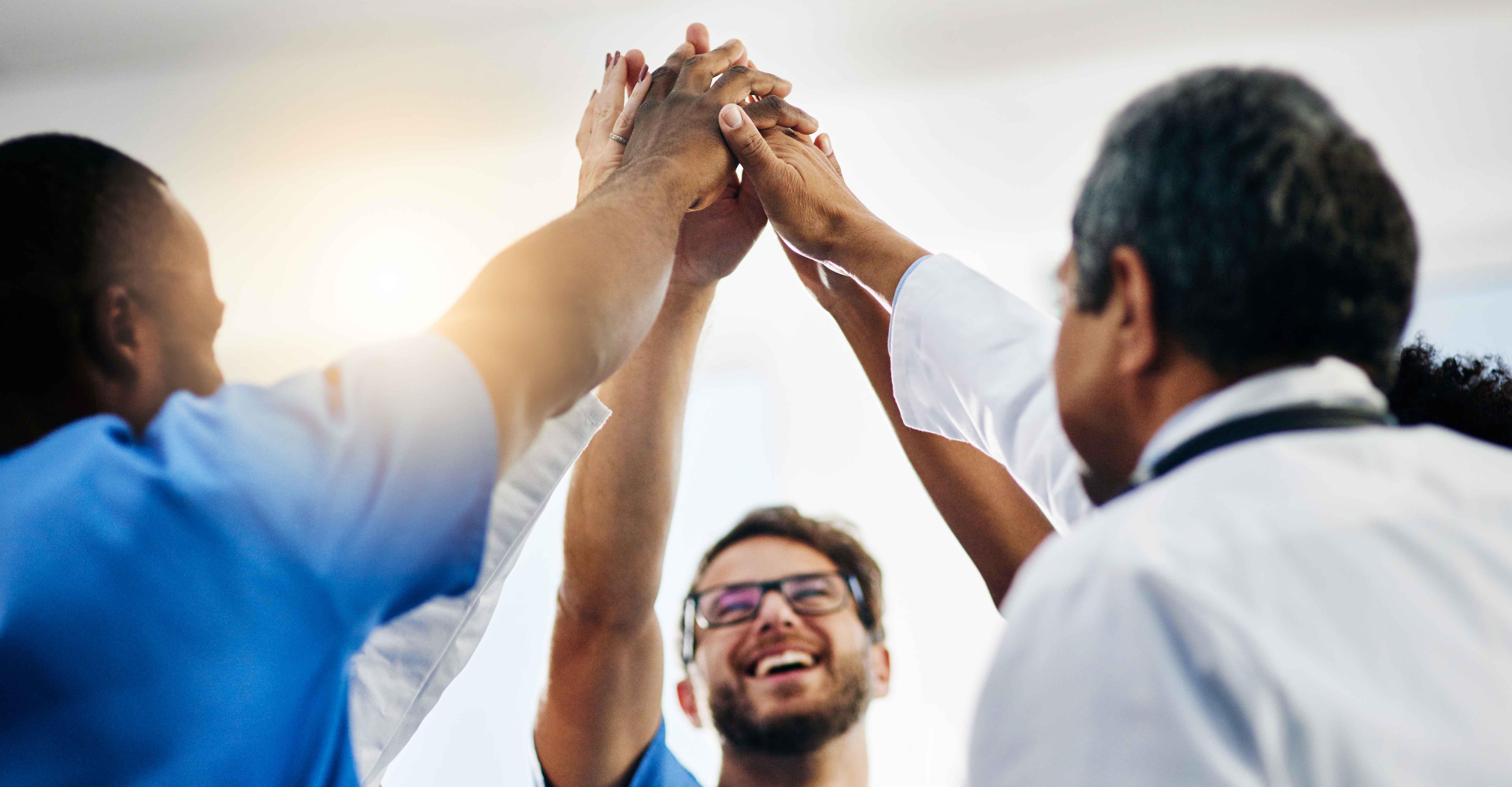 Teams high five after being recognized among the best healthcare companies to work for.