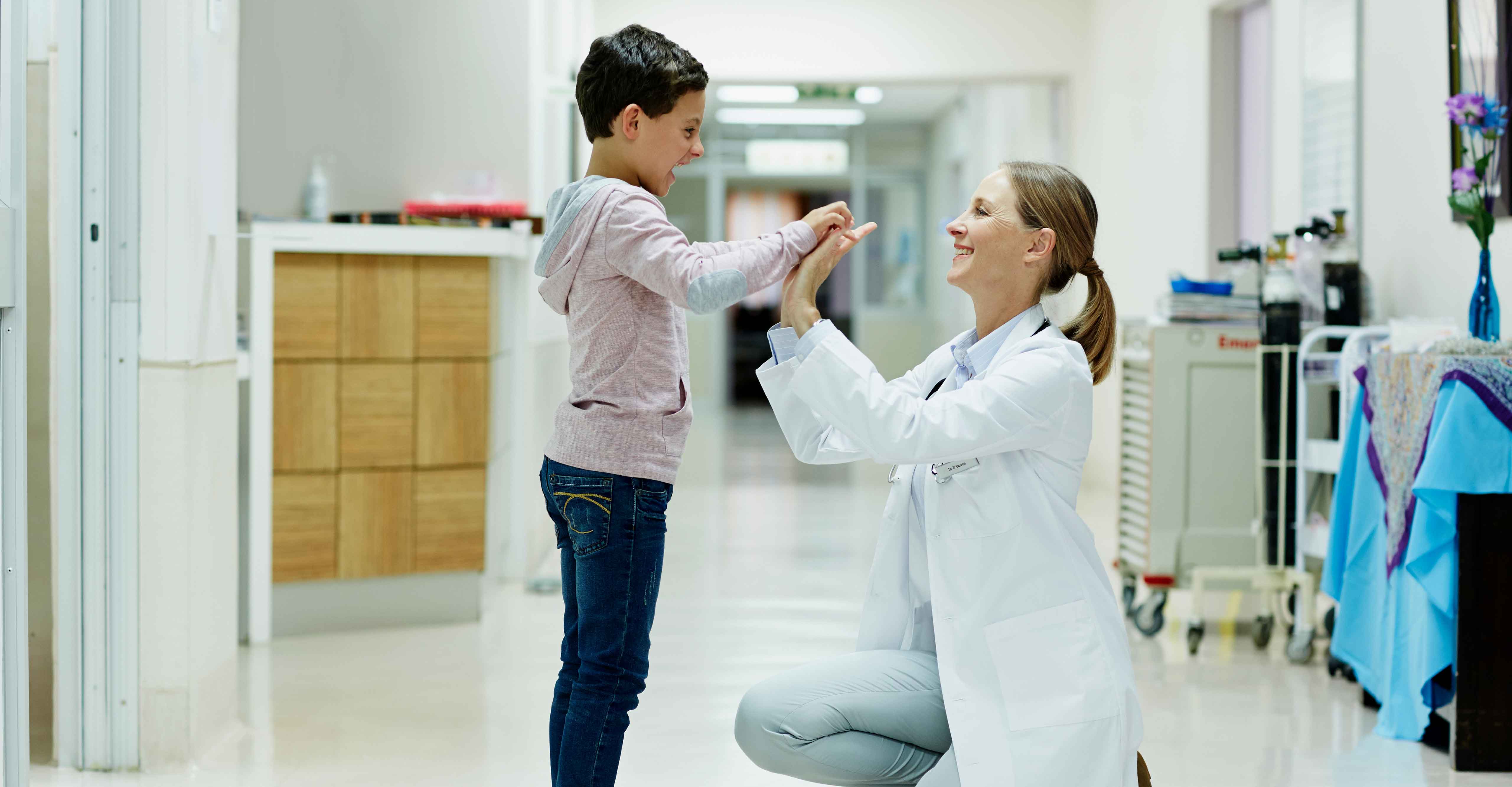 A medical assistant, one of the top healthcare jobs that will grow in the next decade, high fives a pediatric patient.