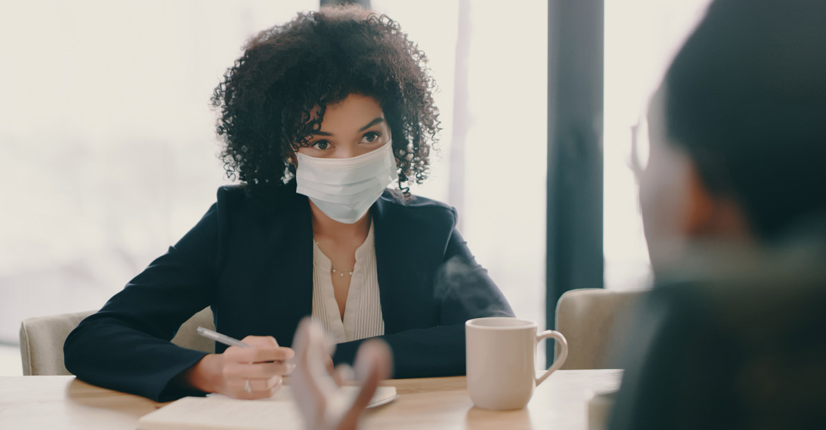 interview with masks over table takes place