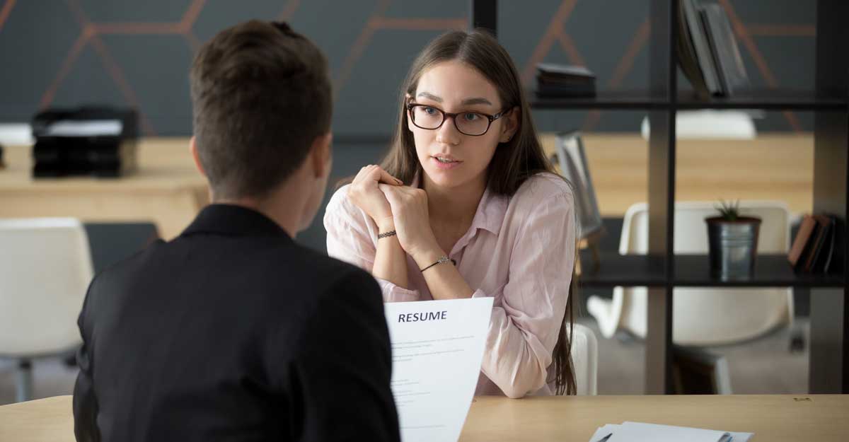 interviewer talks with candidate at table
